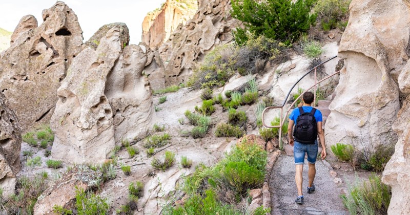 A man takes a walking path in a mountainous area