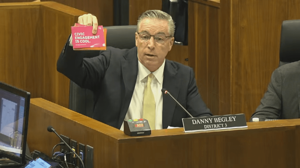 Omaha City Councilmember Danny Begley holds up handwritten cards in support of a proposed citywide ordinance to restore the original language of Nebraska's 2022 ballot initiative regarding minimum wage. | July 14, 2026 | Courtesy: Douglas Omaha Technology Commission