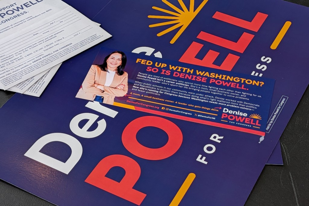 Campaign postcards and signs for Denise Powell, Democratic nominee in Nebraska’s 2nd Congressional District, sit clustered on a table ahead of an Omaha town hall with the candidate. | Photo by Chase Porter/Courier Nebraska