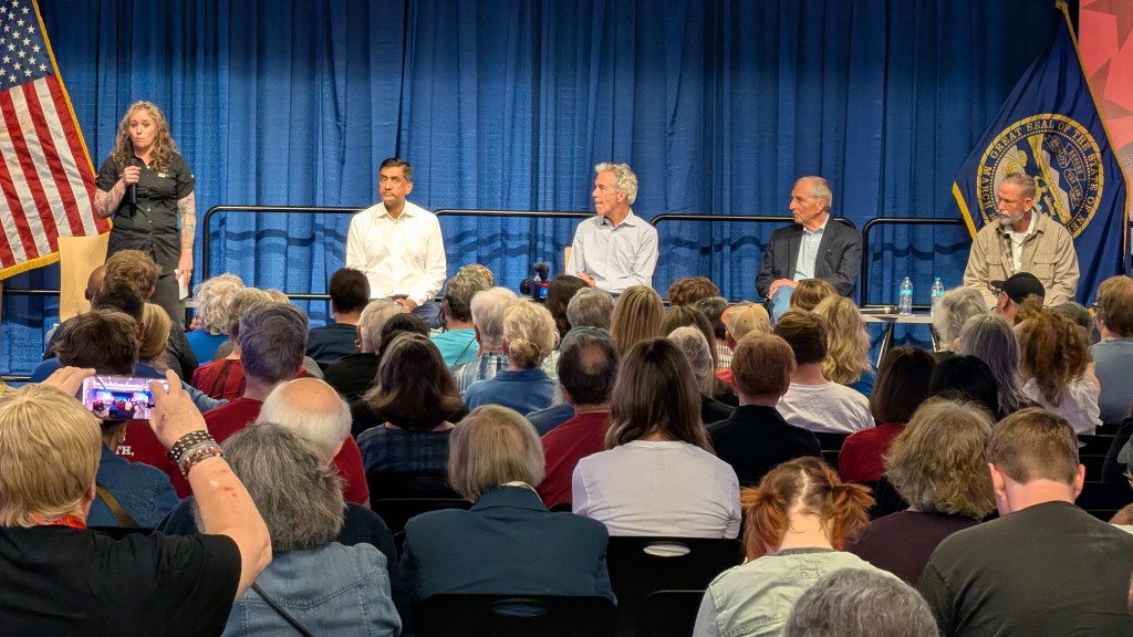 Rachael Nelson, former chair of the Nebraska Libertarian Party, speaks at a “cross-party” town hall in Omaha, Neb., on Saturday, Oct. 24. Seated onstage are, from left, U.S. Rep. Ro Khanna (D-Calif.), former U.S. Rep. Joe Walsh (R-Ill.), former Republican National Committee Chair Marc Racicot and Nebraska independent U.S. Senate candidate Dan Osborn. Photo: Chase Porter/Courier Nebraska.