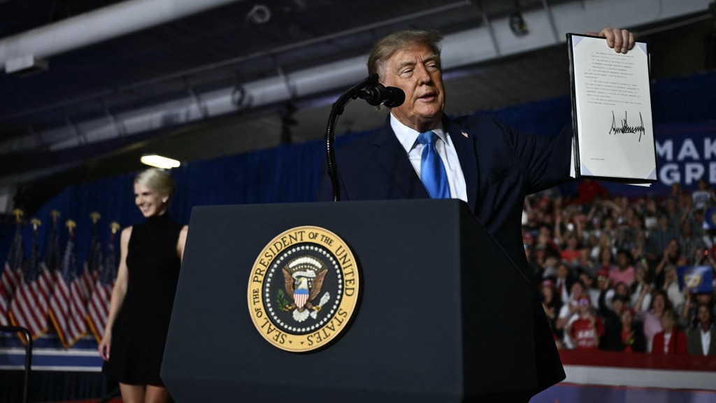 US President Donald Trump shows the crowd an executive order he just signed during a campaign rally at Pinnacle Bank Expo Center in Grand Island, Nebraska, on October 5, 2026. (Photo by Kent NISHIMURA / AFP via Getty Images)